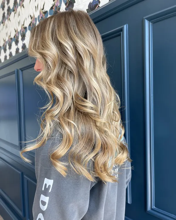 Golden blonde balayage with soft bouncy curls by Aprille at Novum Hair Studio in Mission Valley