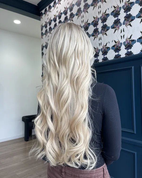 Long icy platinum blonde hair with loose waves by Aprille at Novum Hair Studio in San Diego