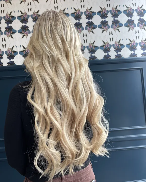 Long bright blonde hair with voluminous loose waves by Aprille at Novum Hair Studio in San Diego